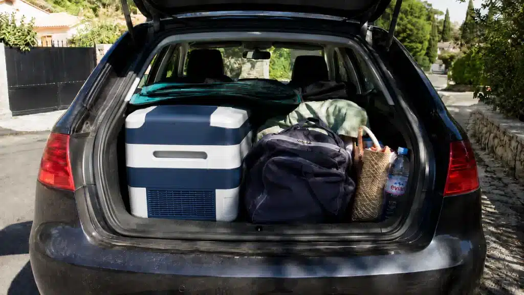 coffre de voiture organisé avec glacière, équipements pour voyager en voiture l'été